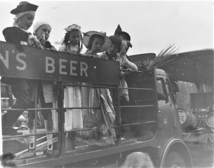 Chiidren on back of a Mann's brewery truck